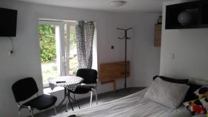 a bedroom with a bed and chairs and a table and a window at Max in Żukowo