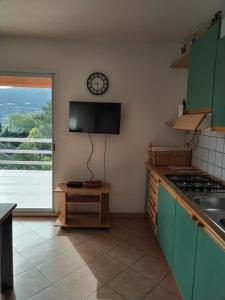 una cucina con piano cottura e orologio a muro di Villa individuelle avec jardin a Sartène