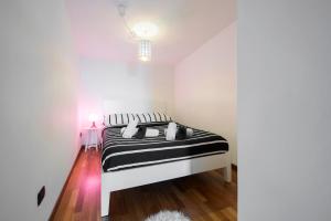 1 dormitorio con 1 cama en una habitación blanca en New Luxury Attic Santa Giulia Expo, en Milán