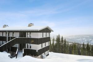 ein Gebäude auf einem schneebedeckten Berg in der Unterkunft Hafjell Front 8pers Ski InOut in Hunder