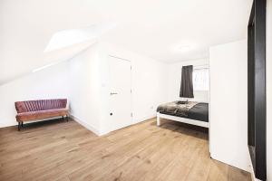 a bedroom with a bed and a chair in it at Stylish London Flat - 5 Sleeper in Ilford