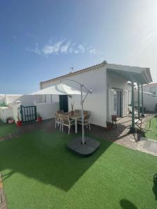 a patio with a table and an umbrella at Casa Brisa Abades in Abades