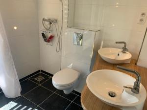 a white bathroom with a toilet and a sink at Herenhuis aan het water in centrum Sluis in Sluis