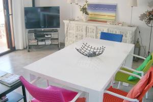 a white table with colorful chairs in a living room at Charming Apartment in Palamós with Sea View and Terrace - 65 sqm in Palamós