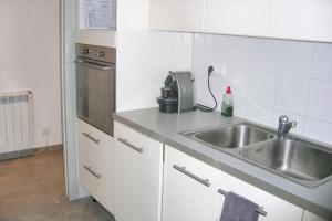 a kitchen with a sink and a microwave at Charming Apartment in Palamós with Sea View and Terrace - 65 sqm in Palamós