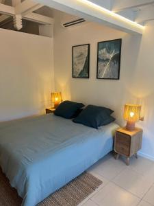 una camera da letto con un letto grande con due lampade di Studio Iguane a St Barthelemy