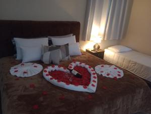 a bed with a heart made out of flowers on it at Cantinho na serra in Monte Verde