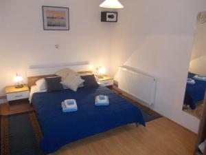 a bedroom with a blue bed with two scales on it at Apartments Pavlić in Rakovica