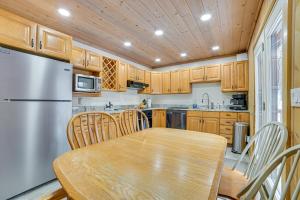 a kitchen with a wooden table and a refrigerator at Less Than 1 Mi to Nubs Nob Ski Cabin with Sauna and Deck! in Harbor Springs