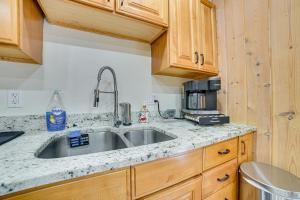 a kitchen with a stainless steel sink and wooden cabinets at Less Than 1 Mi to Nubs Nob Ski Cabin with Sauna and Deck! in Harbor Springs