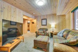 a living room with wooden walls and a large screen tv at Less Than 1 Mi to Nubs Nob Ski Cabin with Sauna and Deck! in Harbor Springs