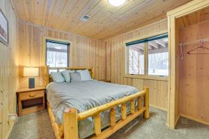 a log cabin bedroom with a bed and a window at Less Than 1 Mi to Nubs Nob Ski Cabin with Sauna and Deck! in Harbor Springs