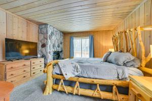 a bedroom with a bed and a flat screen tv at Less Than 1 Mi to Nubs Nob Ski Cabin with Sauna and Deck! in Harbor Springs