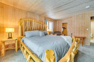 a bedroom with a bed in a room with wooden walls at Less Than 1 Mi to Nubs Nob Ski Cabin with Sauna and Deck! in Harbor Springs