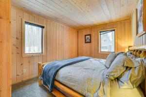 a bedroom with a bed in a room with wooden walls at Less Than 1 Mi to Nubs Nob Ski Cabin with Sauna and Deck! in Harbor Springs