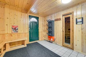 a room with wooden walls and a green door at Less Than 1 Mi to Nubs Nob Ski Cabin with Sauna and Deck! in Harbor Springs