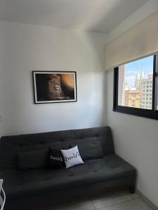 a couch in a living room with a picture of a lion at TrevizZo Catedral da Sé in São Paulo