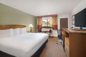 a hotel room with a bed and a desk and a television at Best Western Red Hills in Kanab