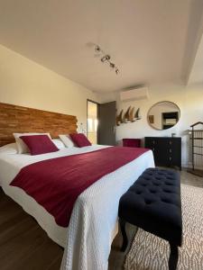a bedroom with a large bed with red and white sheets at Demeures du Bord de Seine in Samoreau +47 photos