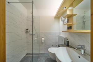 a bathroom with a shower and a sink and a toilet at Hotel Montafon Moments in Sankt Gallenkirch