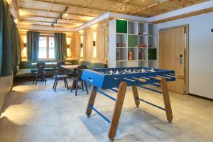a room with a ping pong table and chairs at Hotel Montafon Moments in Sankt Gallenkirch