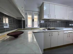 a large kitchen with white cabinets and a sink at El caserío de la abuela in Cabezuela del Valle