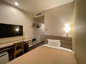 a hotel room with a bed and a flat screen tv at Kusatsu Daiichi Hotel - Vacation STAY 99281v in Kusatsu