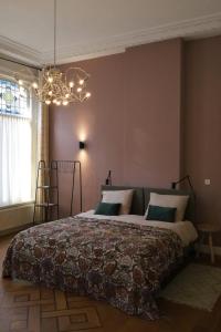 a bedroom with a large bed with a chandelier at Bij Joseph in Den Bosch