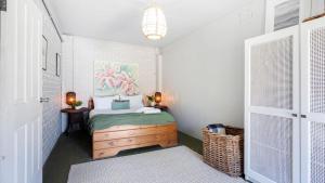 a bedroom with a bed with a painting on the wall at Casa Blu in Culburra Beach