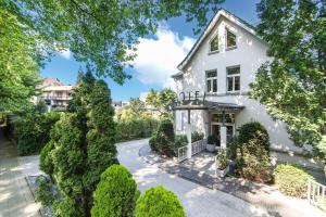 an exterior view of a white house with trees at Hotel Das Lola in Essen