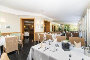 a dining room with white tables and chairs at Hotel Das Lola in Essen +21 photos