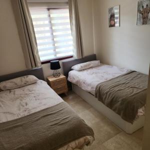 two beds in a small bedroom with a window at Geweldig Appartement in Los Alcázares direct aan de Boulevard in Los Alcázares
