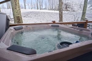 a jacuzzi tub with snow in a yard at The Tee House in Beech Mountain