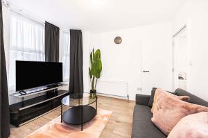 a living room with a couch and a tv at Amazing 4 Sleeper Great Location in Ilford