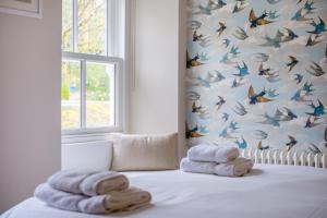 a room with towels on a bed with a wall with butterflies at Fellfoot Cottage in the Lake District in Staveley