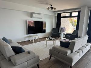 a living room with two couches and a flat screen tv at Villa Paradise in Milas