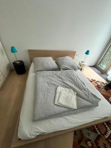 a bed with a white comforter and a pillow on it at Luxury Apartment Berlin Mitte in Berlin