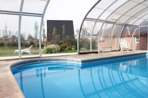 a swimming pool with a glass house and a swimming poolvisor at Cabañas Buena Vista in Sierra de la Ventana