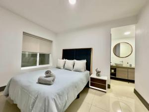 a bedroom with a large bed and a bathroom at 2 Story Condo TJ 3BDR 3BR in Tijuana