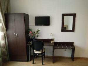 Habitación con escritorio con silla y espejo. en Hotel Alfa en Neu Isenburg