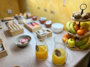 a table with two glasses of orange juice and a bowl of fruit at Casa Rural La Fuente del Jerte in Navaconcejo