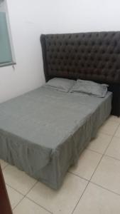 a bed with a padded headboard in a room at Apartamento 102 Encantador in Vitoria da Conquista in Vitória da Conquista