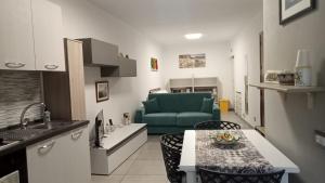 a kitchen and a living room with a green couch at Casa Spinuzza 4 in Cefalù