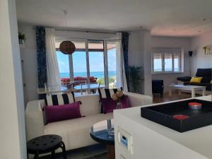 a living room with a couch and a view of the ocean at Mazagón El Pez de Plata in Mazagón