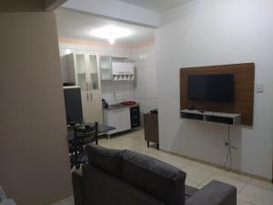 a living room with a couch and a flat screen tv at Apartment 104 charmoso in Vitória da Conquista