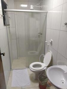 a bathroom with a shower and a toilet and a sink at Apartment 104 charmoso in Vitória da Conquista