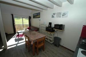 a living room with a table and a room with a kitchen at La Grange du Devezou in Saint-Jacques-des-Blats