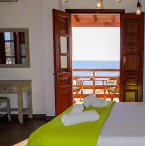 a bedroom with a bed and a balcony with the ocean at Mistral-Patmos in Patmos