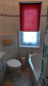 bagno con servizi igienici e finestra rossa di Bernauer Stübchen a Bernau bei Berlin