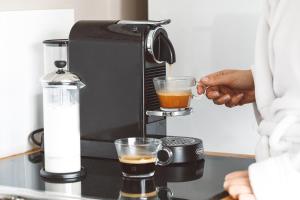 a person is making a drink in a coffee maker at Seaview-Waterfront-Shutters by the Sea-On the Coastal Walk-Private and Quiet in Kiama +24 photos